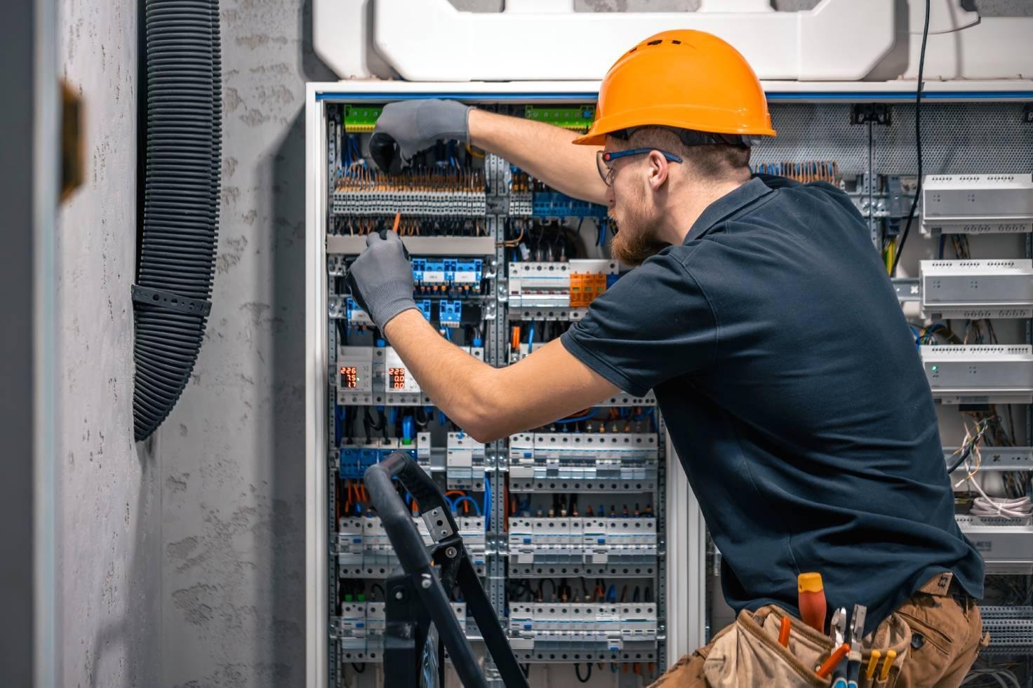 male electrician working switchboard with fuses.jpg