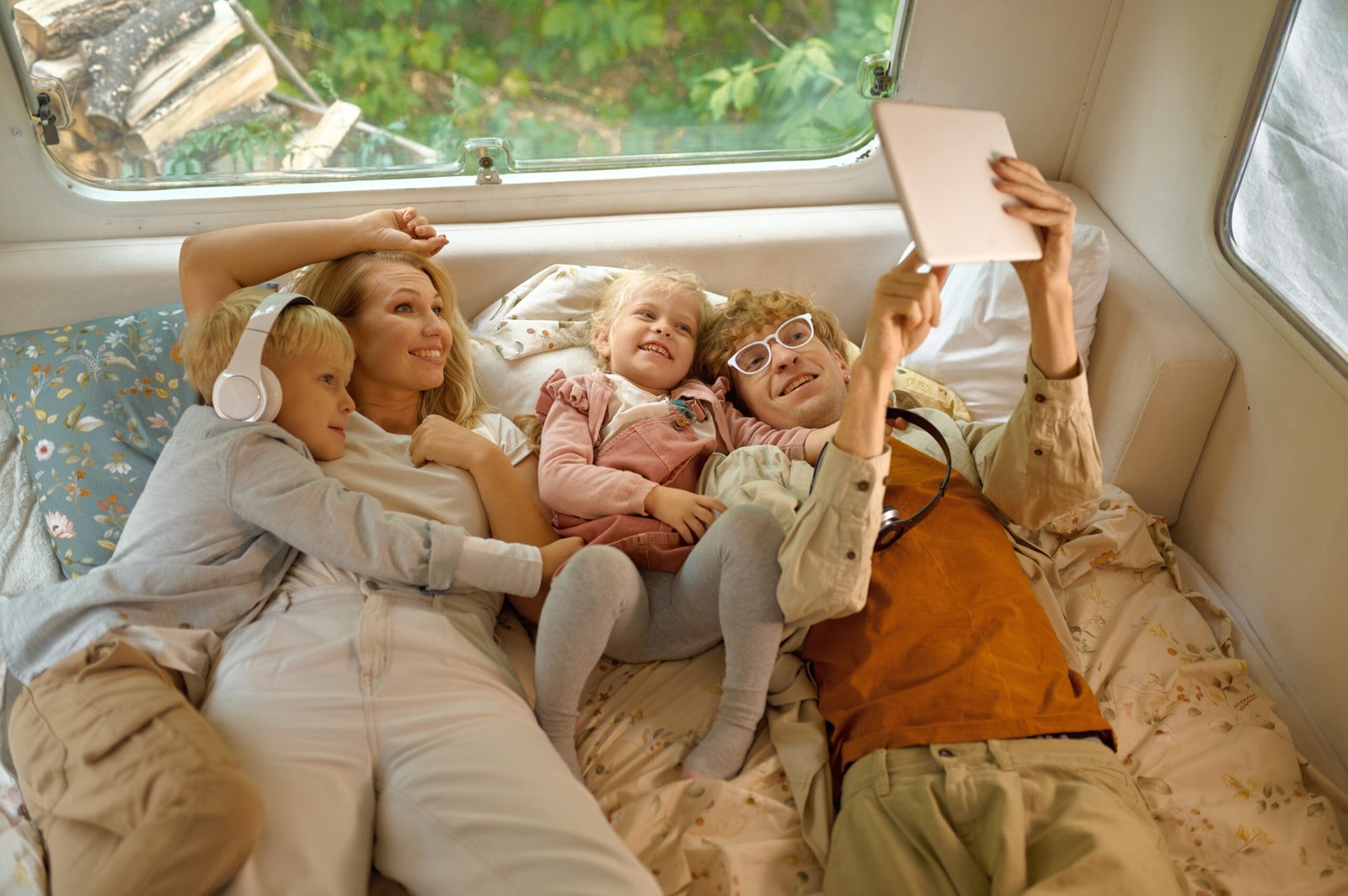 cheerful family lying in bed in motorhome, camping